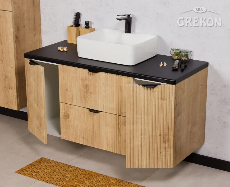Szafka do łazienki w kolorze naturalny dąb z frontami w postaci lameli i białą ceramiczną umywalką